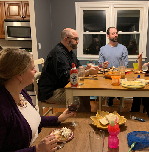 kim sitting at a table much too small and removed from the other adults