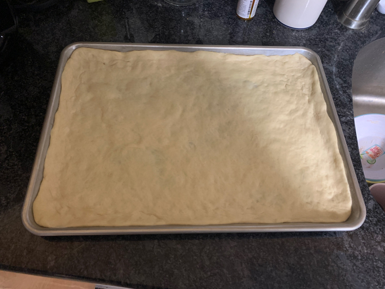 pre-baked pizza dough in a half-sheet pan