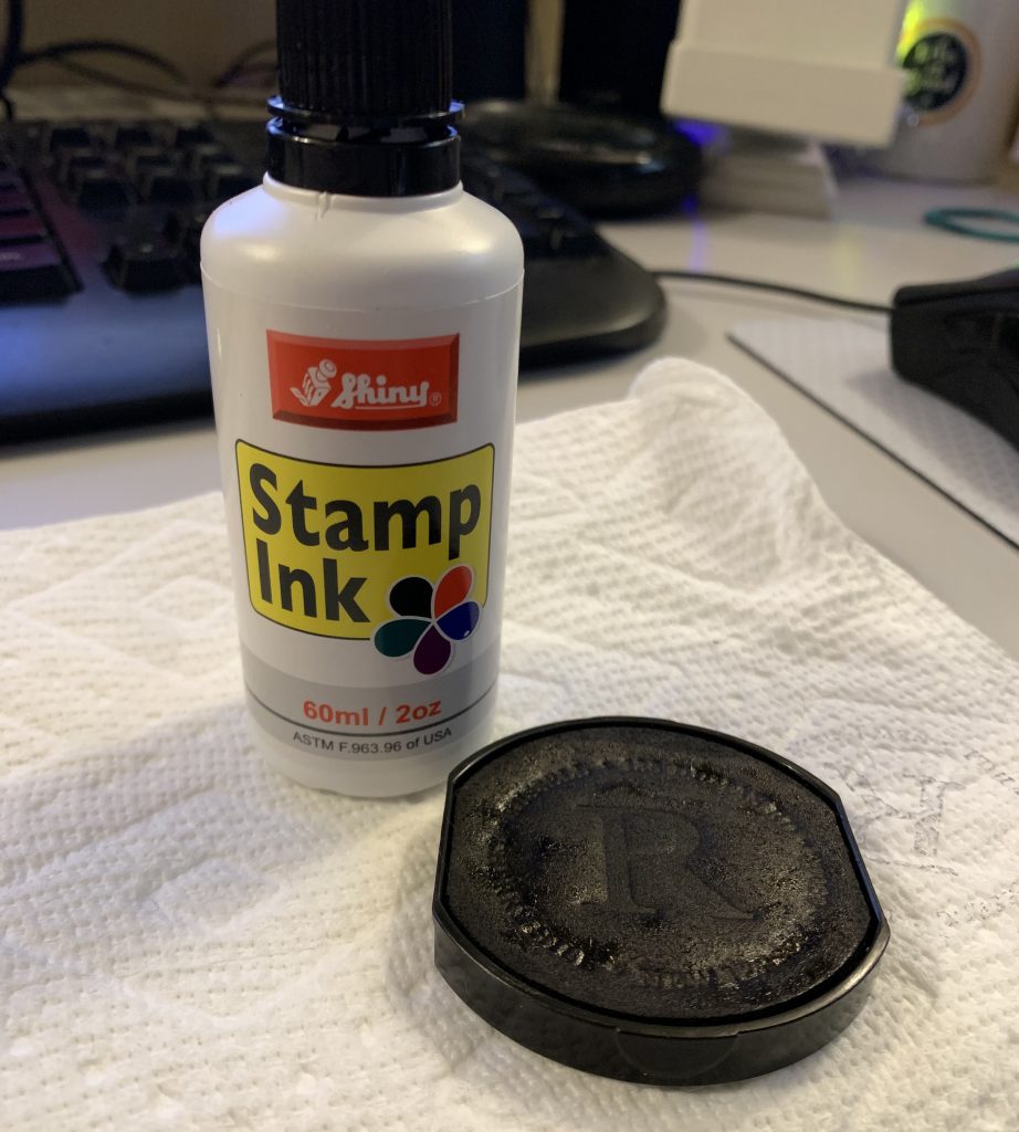 an ink bottle and a stamp pad that was removed from an expressionery self-inking return address stamp