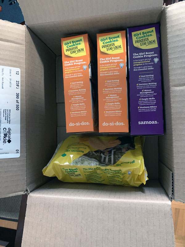 a box with four boxes of girl scout cookies inside