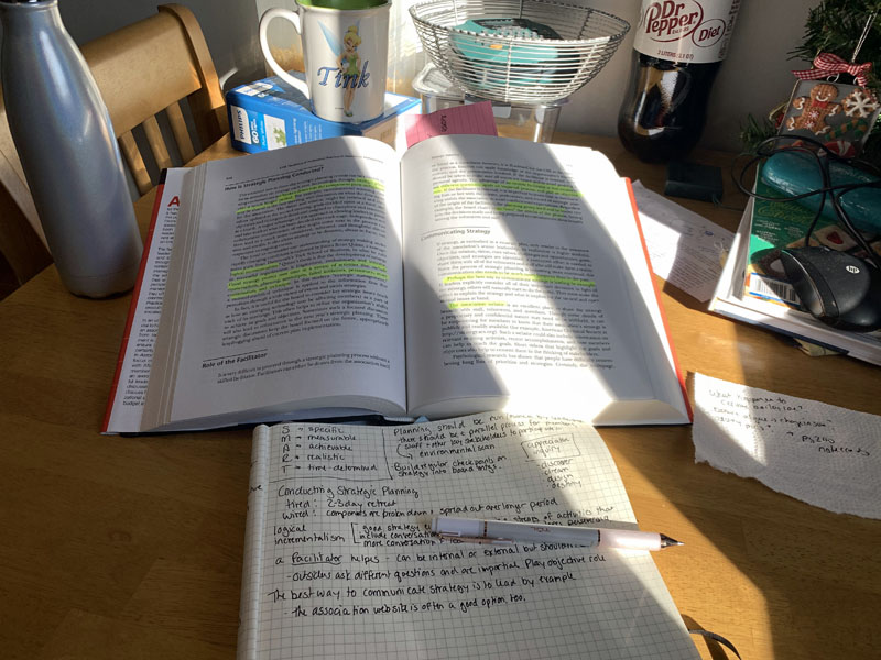 a text book and notebook on a kitchen table with sunlight streaming in