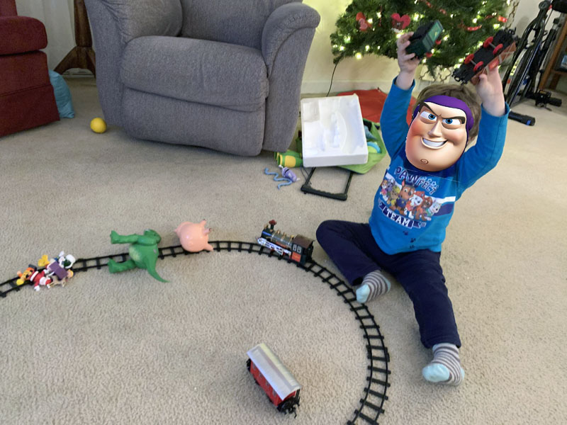 tiny diabolical child with his toys on a train track