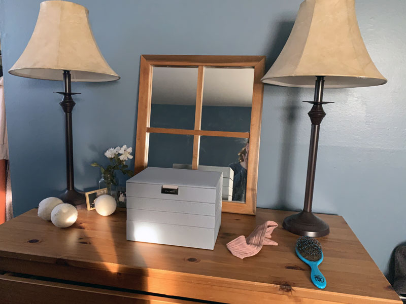 image of tidy dresser with jewelry box, brush, headband, and dryer balls.