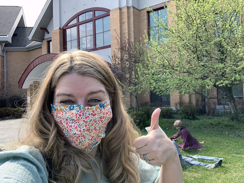 kim giving the thumbs-up in front of the library.