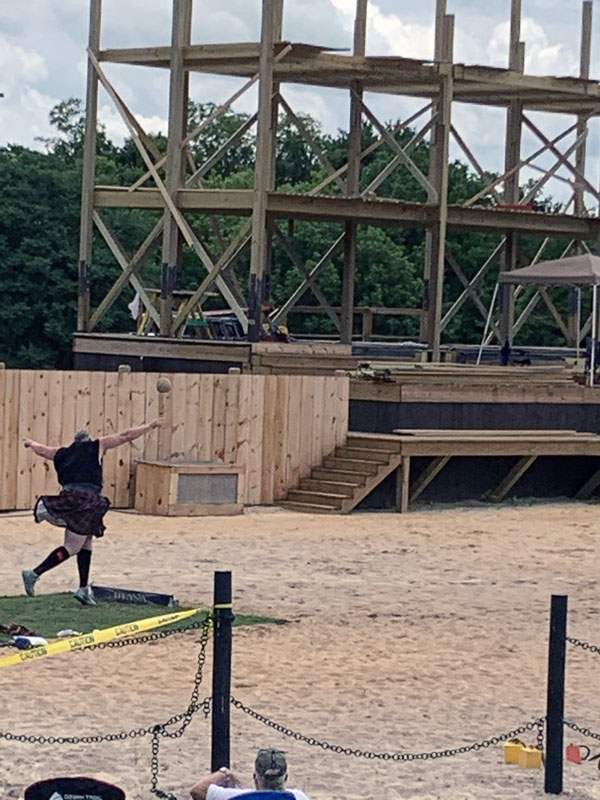 a kilted man tossing a stone