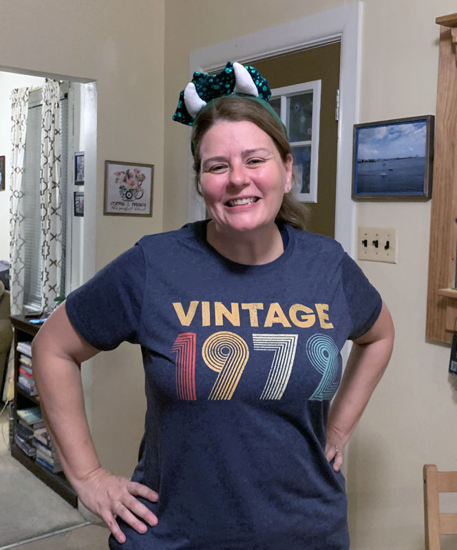 kim in a shirt that says Vintage 1972 and a headband with dinosaur horns on it.