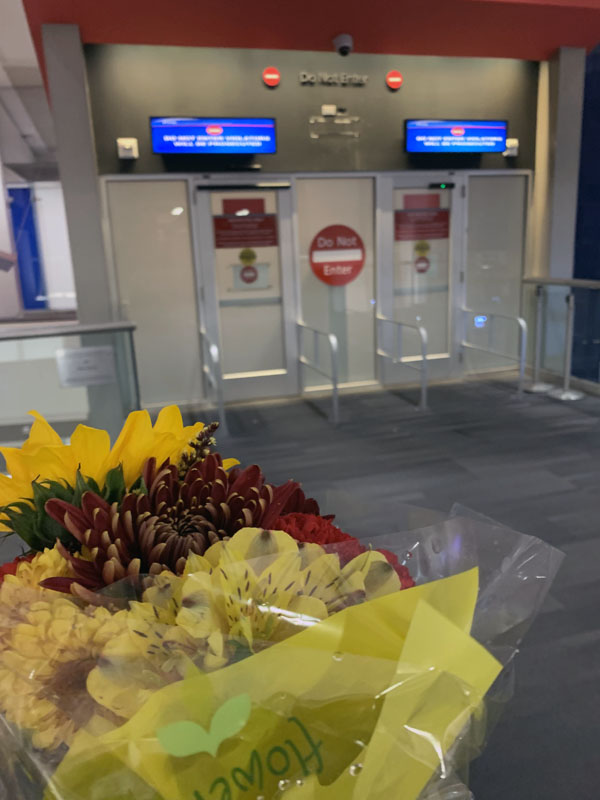 a bouquet of flowers, airport security in the background