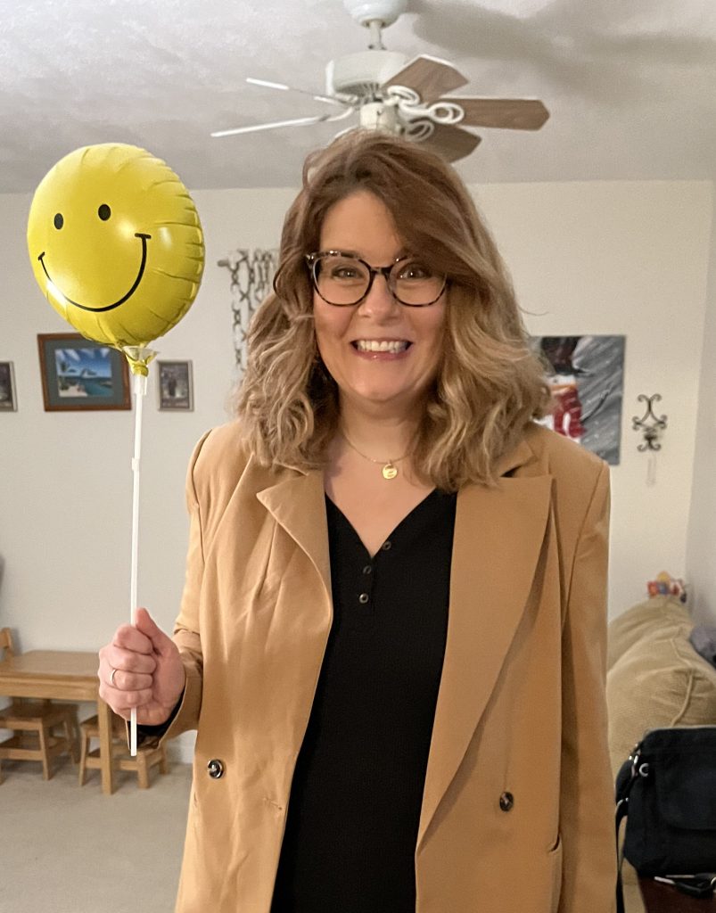 kim, dorkily holding a balloon