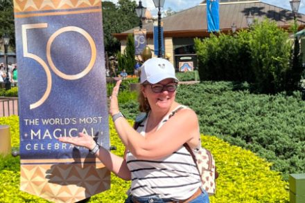 kim cheesing with a '50' sign at walt disney world in September