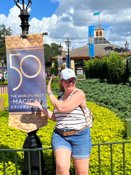 kim cheesing with a '50' sign at walt disney world in September