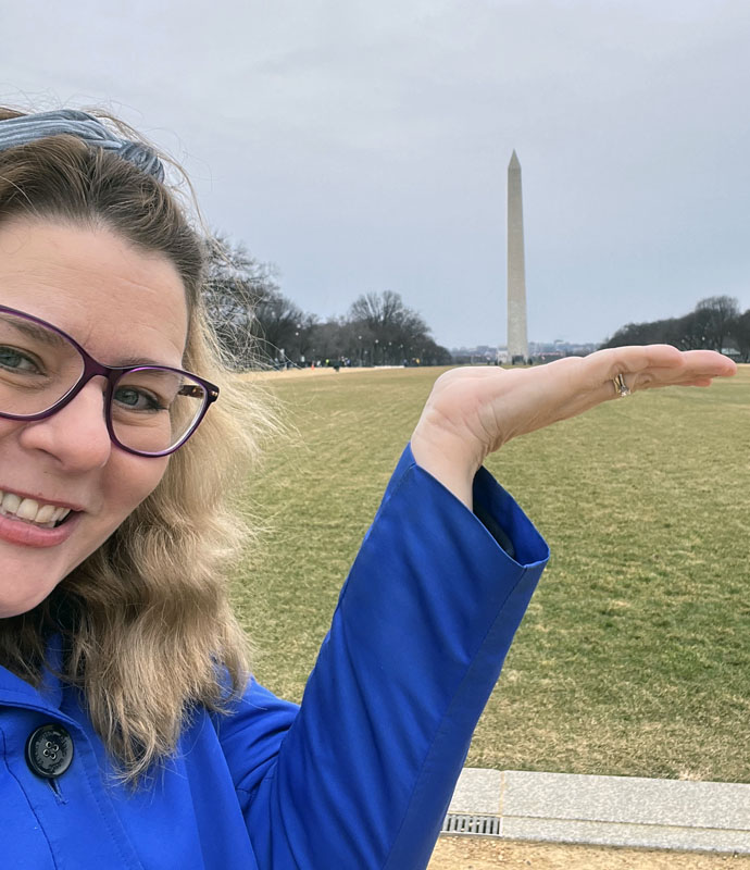 Kim, cheesily pretending to hold the Washington Monument in her hand.