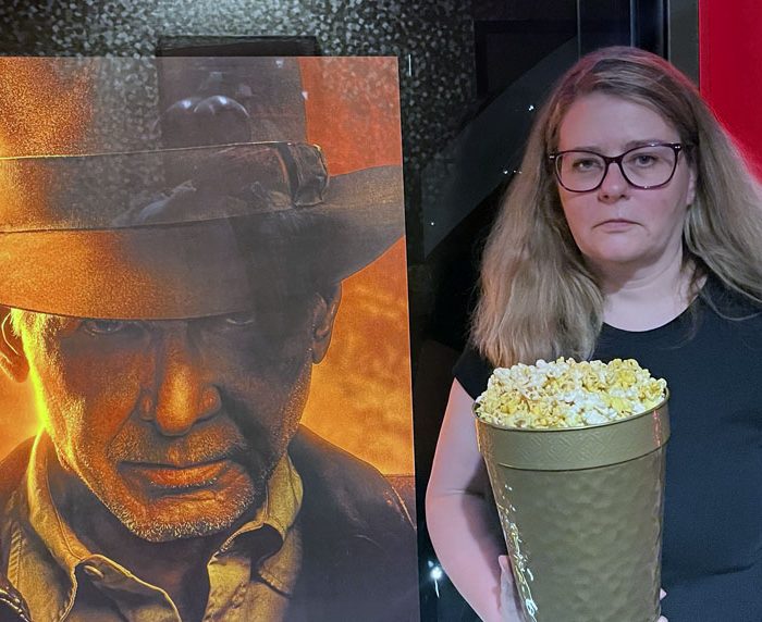 kim, deadpan with a commemorative popcorn bucket