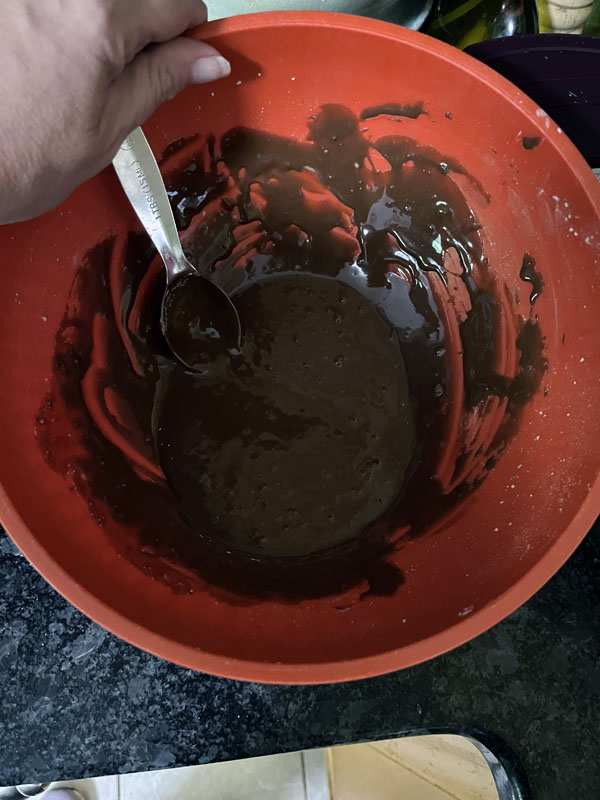 chocolate frosting in a bowl. The frosting is very pourable.