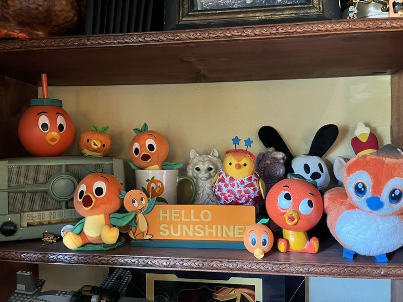 a shelf with too many Orange Bird items on it, along with a vintage radio.