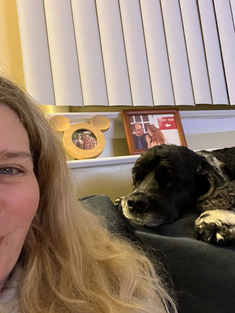 A half-face shot of Kim, which focuses more on Murphy snoozing next to her atop the sofa cushion