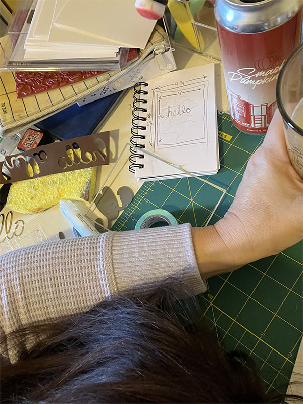 Kim's head down on the crafting table, a beer in her hand as she realizes her dimensions weren't correct.