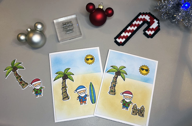 two finished holiday cards with santa on a beach with palm trees