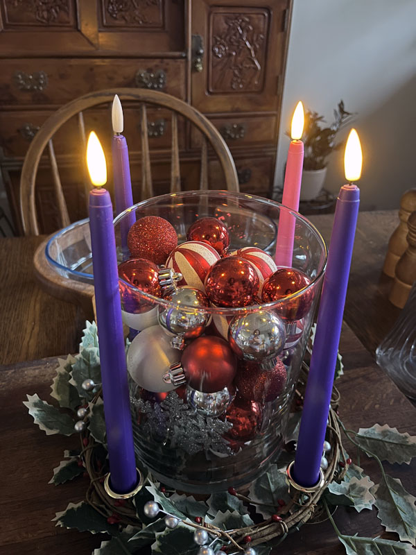 Kim's advent wreath with three candles lit: 2 purples and a pink.