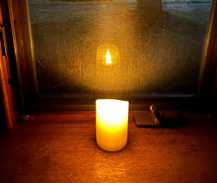 a flameless candle in my front window on the longest night of the year. I used Photoshop's AI function to remove the water rings from the wood.