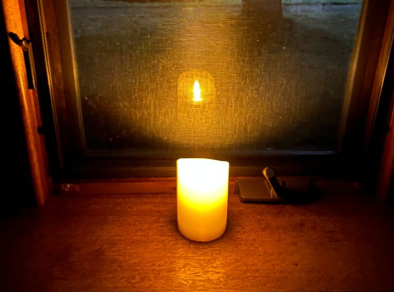 a flameless candle in my front window on the longest night of the year. I used Photoshop's AI function to remove the water rings from the wood.