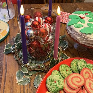 Kim's advent wreath with all 4 candles list, surrounded by cookies and a cake.