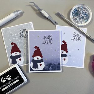 snowman cards surrounded by craft supplies