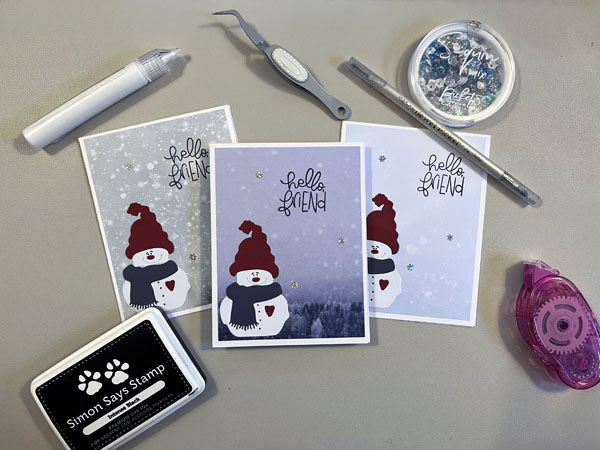 snowman cards surrounded by craft supplies