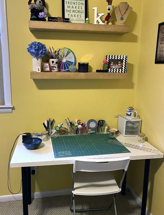 my new craft corner, a few shelves with crafty tchotchkes above my beat up IKEA table and $10 chair