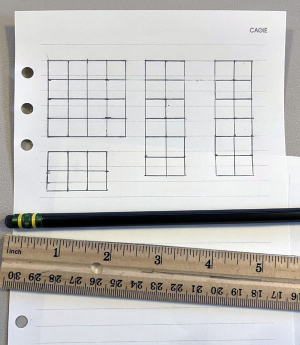 a preliminary garden grid drawn on notebook paper, with a pencil and ruler next to it