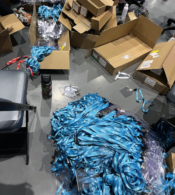 a gigantic pile of sea-blue lanyards with empty plastic badge holders clipped to them