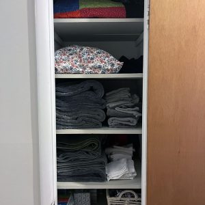 my linen closet, with blankets, sheets, and towels, all folded.