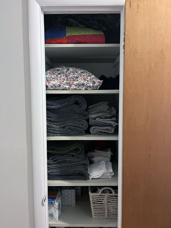 my linen closet, with blankets, sheets, and towels, all folded.