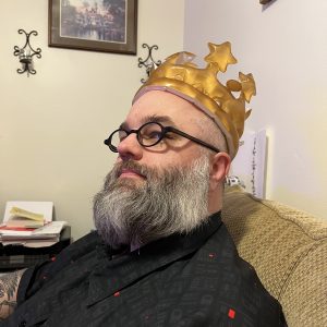 my husband regally wearing an inflatable crown