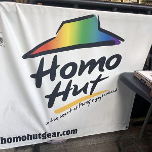 a sign in philadelpha for 'homo hut - in the heart of Philly's gayborhood'