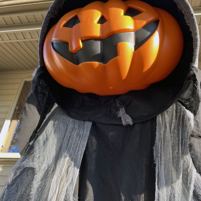 Looking up at a giant jack-o-lantern on a ghoulish body. But he is not a jack-o-lantern. His name is Lewis.