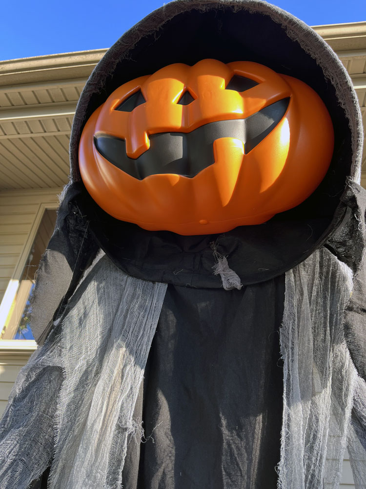 Looking up at a giant jack-o-lantern on a ghoulish body. But he is not a jack-o-lantern. His name is Lewis.