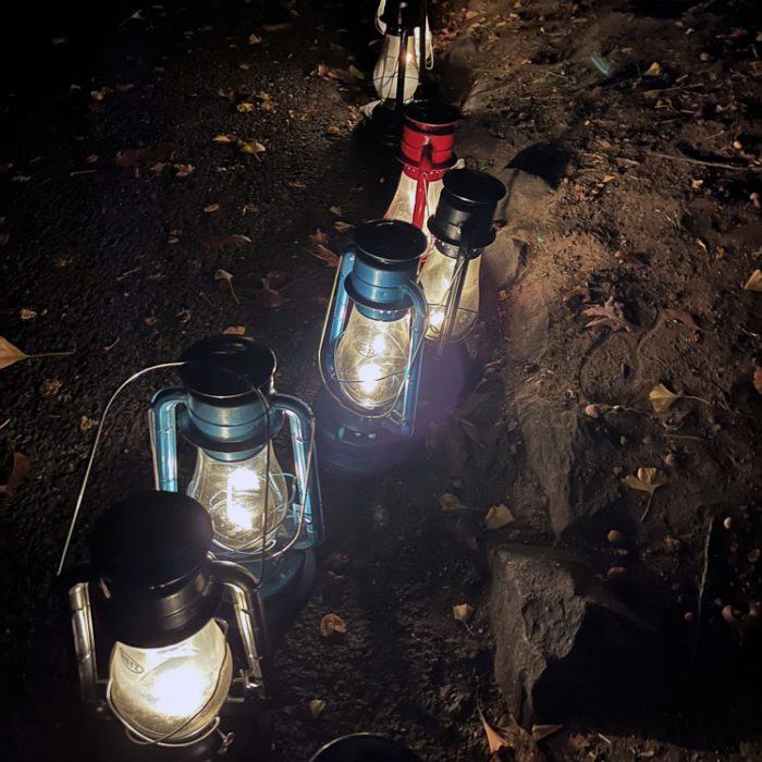 a line of kerosene lanterns in the dark