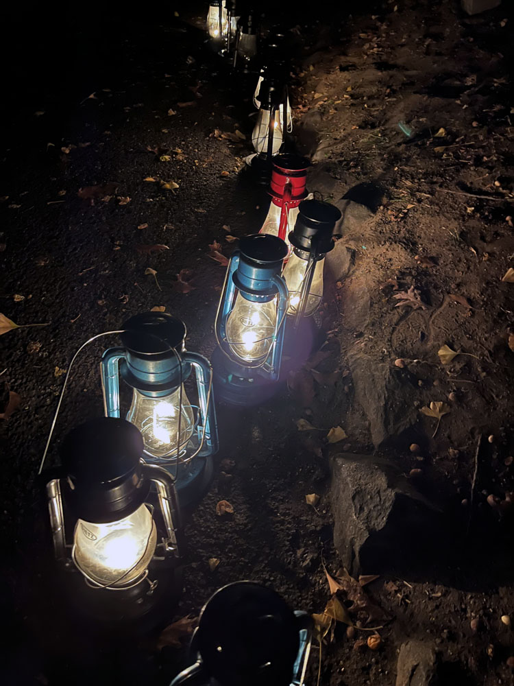 a line of kerosene lanterns in the dark