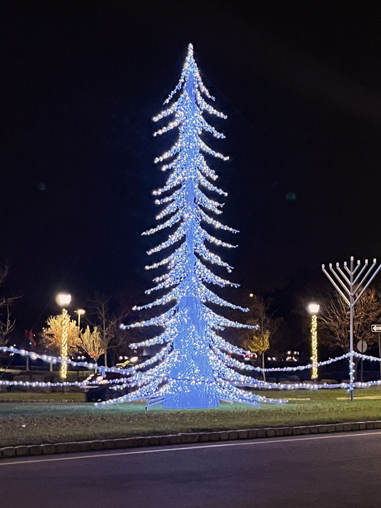 a lit christmas tree and an unlit menorah