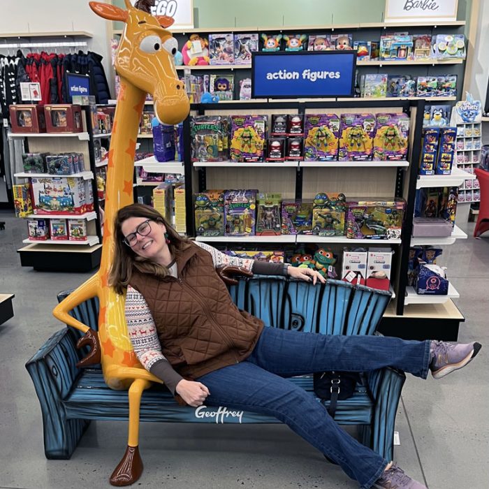 kim snuggling with Geoffrey, the ToysRUS mascot, in a Macy's on Black Friday