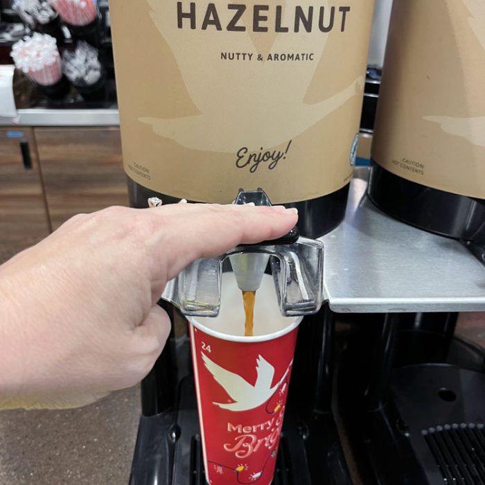 a 24 ounce red wawa cup under a hazelnut coffee urn