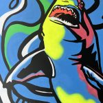 it's a mural of a shark painted in vibrant blue, black, and white with neon yellow and pink accents