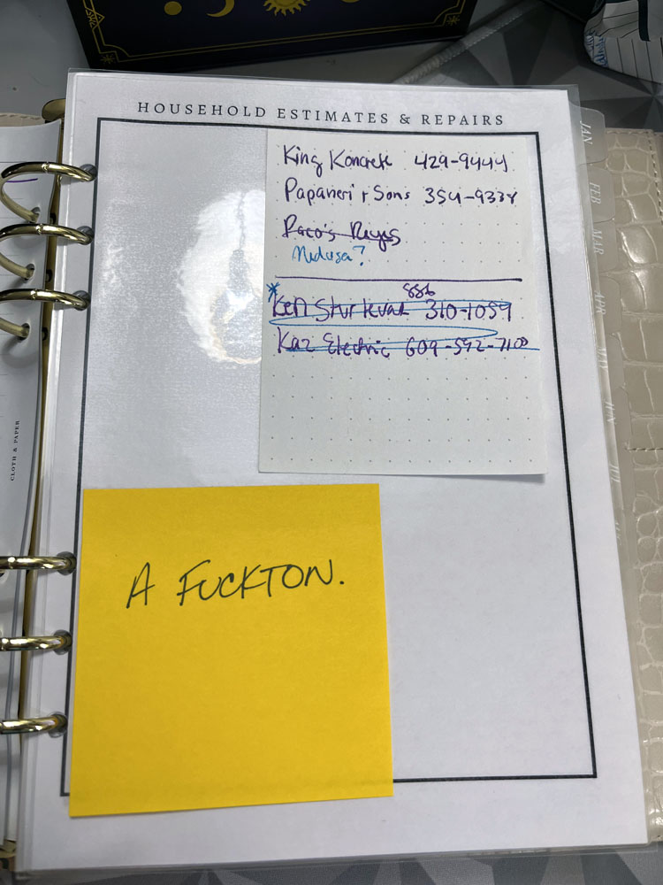 a laminated 'dashboard' insert that says household estimates and repairs. there are phone numbers on it and a post-it note with "a fuckton" in WM's writing