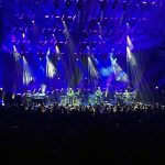 the band phish performing onstage. There are many lights and a haze of smoke
