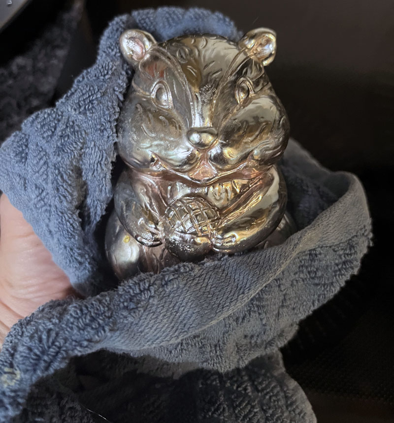 a shiny squirrel statue that lives next to the stove in our kitchen. I'm wiping the grease off of it