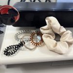 Five ponytail holders on my desk: three coiled ones, one traditional elastic and one satin scrunchie.