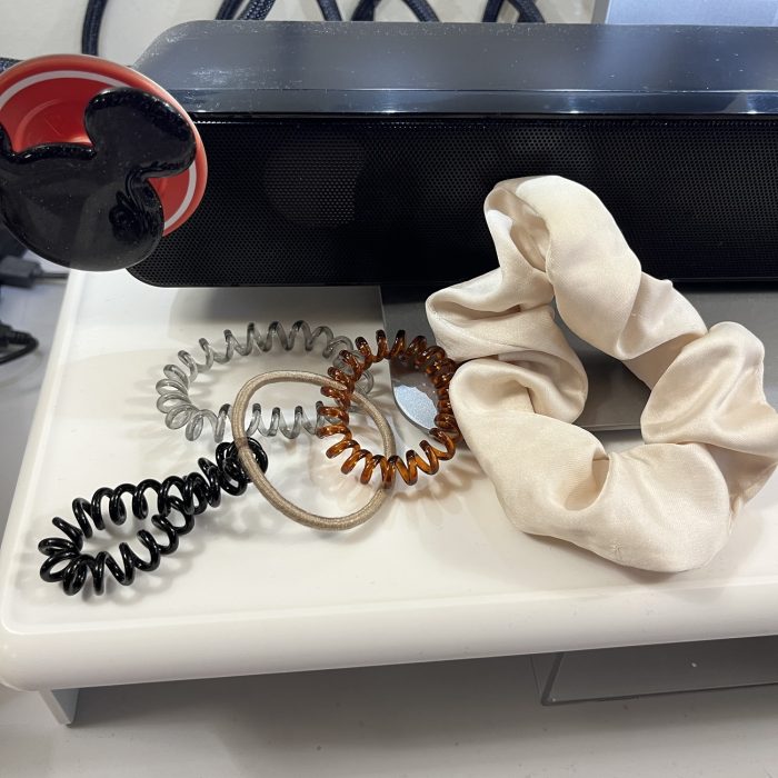 Five ponytail holders on my desk: three coiled ones, one traditional elastic and one satin scrunchie.