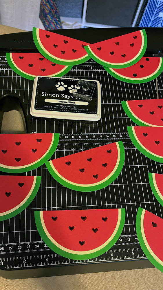 a dozen half-watermelon shapes, with little black hearts for seeds