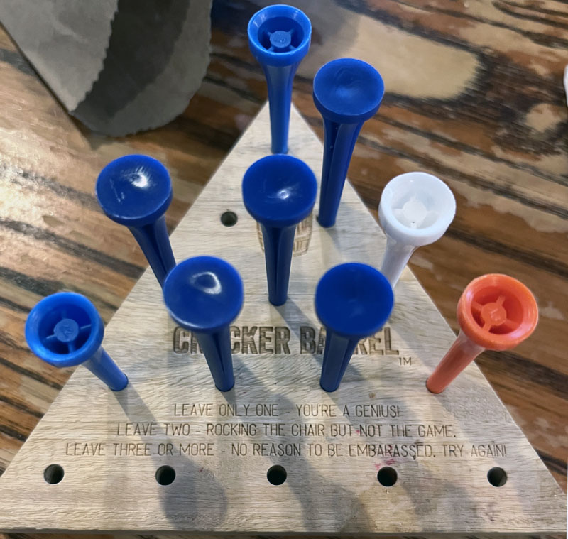 the new cracker barrel peg game. the text says "leave only one, you're a genius, leave two, rocking the chair not the game, leave three or more, no need to be embarrassed try again"