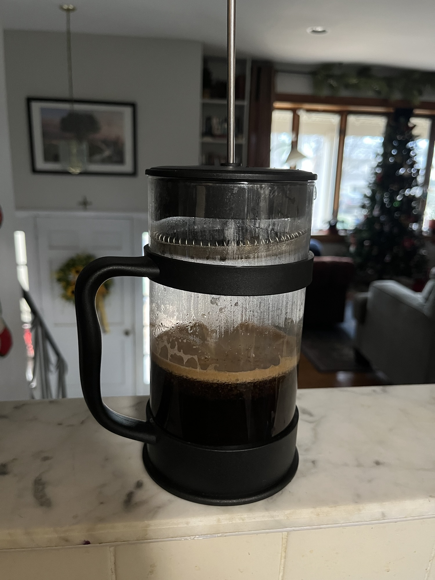 coffee brewing in a french press on my kitchen shelf, a place where i never in a million years would brew coffee, but it's a nice place to stage a photo